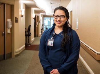 Nora Arellano standing in workplace hallway