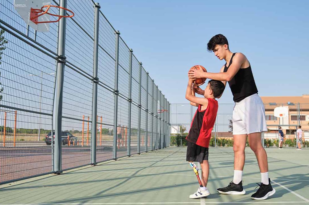 Individual showing a child how to shoot a basketball