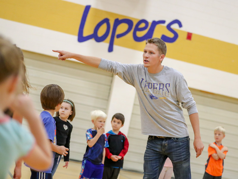 UNK student instructing school age students in gym