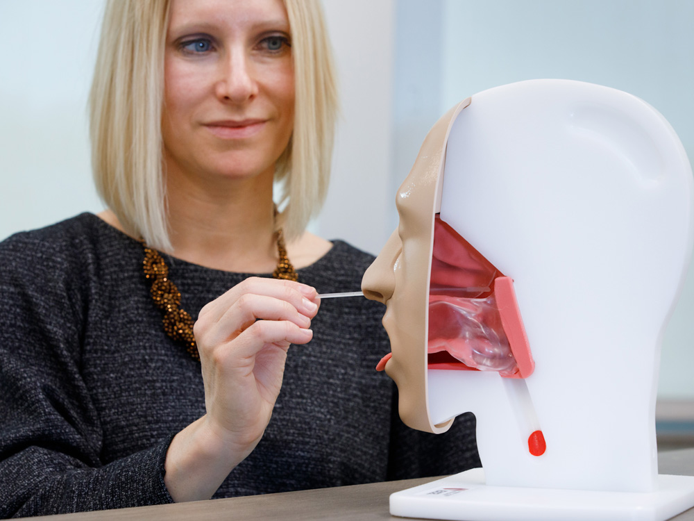 Christie Barnes performs a nasal swab for COVID on the ONPACE trainer.