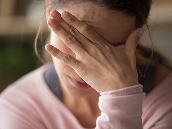 girl covering eyes in distress