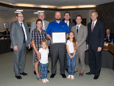 Pictured: Back row- Jim Davis, Director of Police and Parking Services; Chancellor Kristensen; President Bounds; Regent Schaffer. Front rows- Rachel Fast, wife; Beckitt Fast, daughter; Ricci Fast, recipient; Broxlynn Fast, daughter; Jon Watts, Vice Chancellor Business and Finance.